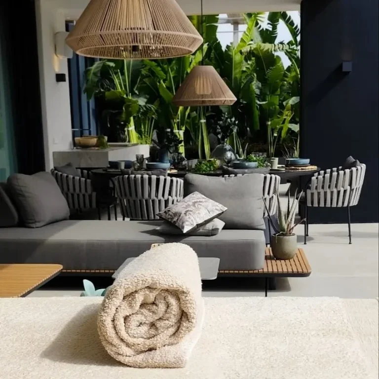 Home massage Marbella A towel rolled up on a massage table for a home massage on the terrace of a modern villa in Marbella, with a modern-style living room and pl