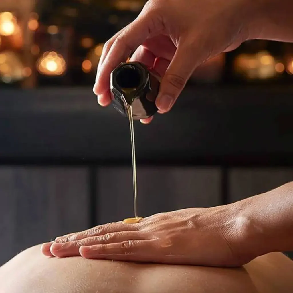 SENSE8 Home Massage Services Table with a decorative plant next to a towel and a blue pool in the background.